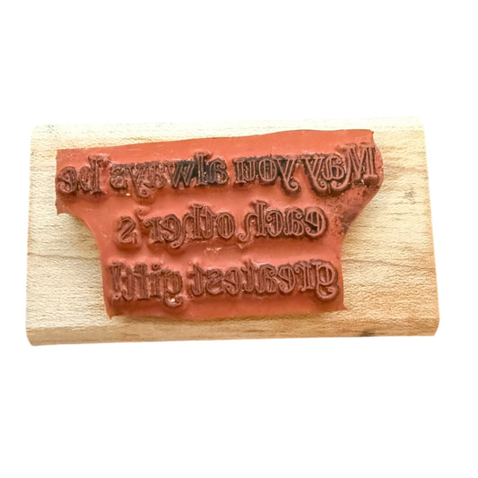 Wooden stamp with carved text on a white background