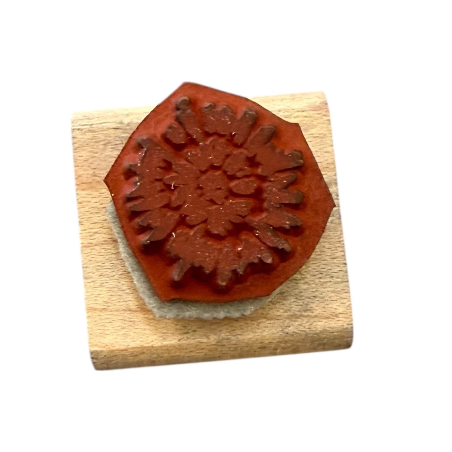 Wooden stamp with a red floral design rubber stamp on a white background