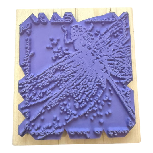 A purple rubber stamp with an embossed dragonfly design, mounted on a light-colored wooden block against a white background.