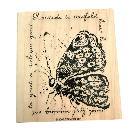 Butterfly rubber stamp with text on a wooden block