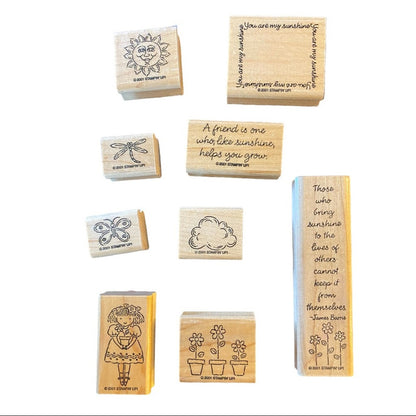 A set of wooden rubber stamps with assorted designs and inspirational quotes, arranged on a plain white background.
