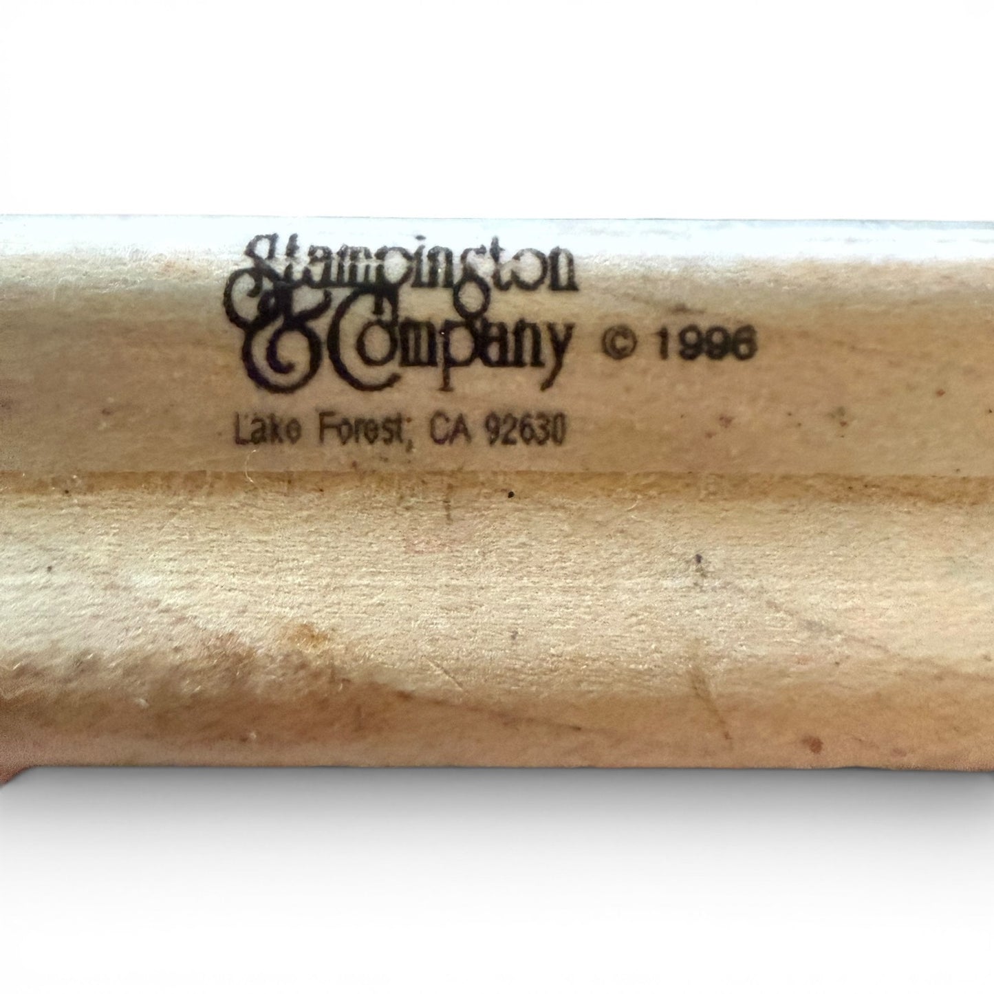 Close-up of a wooden block with 'Stampington & Company' branding and address.