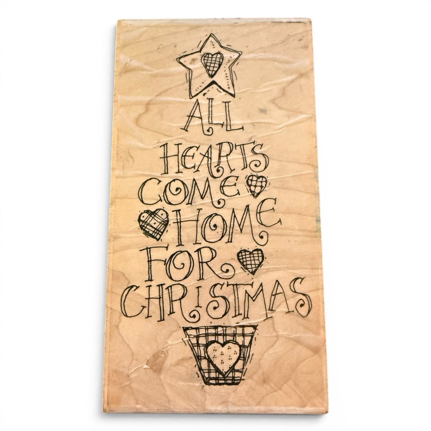Wooden stamp with Christmas-themed text and heart designs on a white background