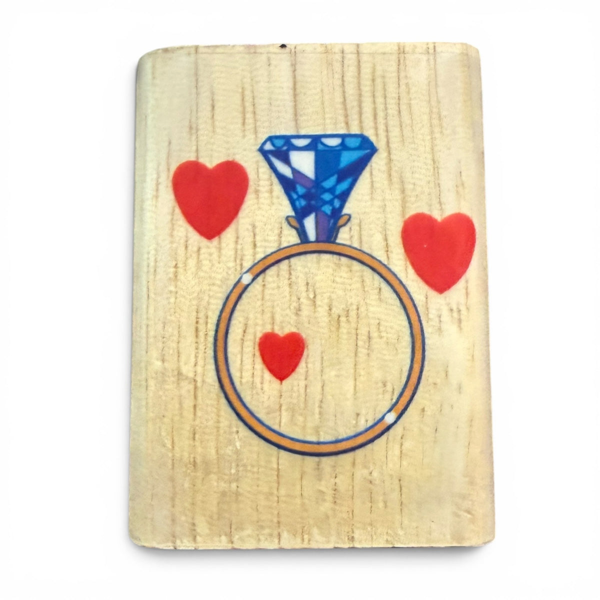 Wooden block stamp with a diamond ring and hearts design on a white background
