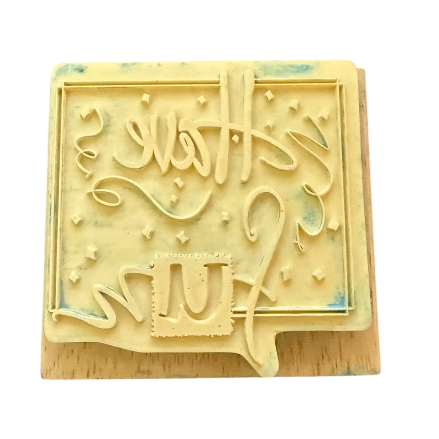 Back of a rubber stamp on a wood block, shown on a white background.