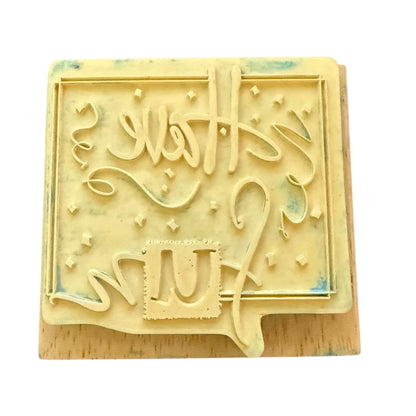 Back of a rubber stamp on a wood block, shown on a white background.