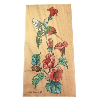 A rectangular wooden block stamp featuring a illustration of a green hummingbird and red flowers with green leaves, shown against a plain white background.