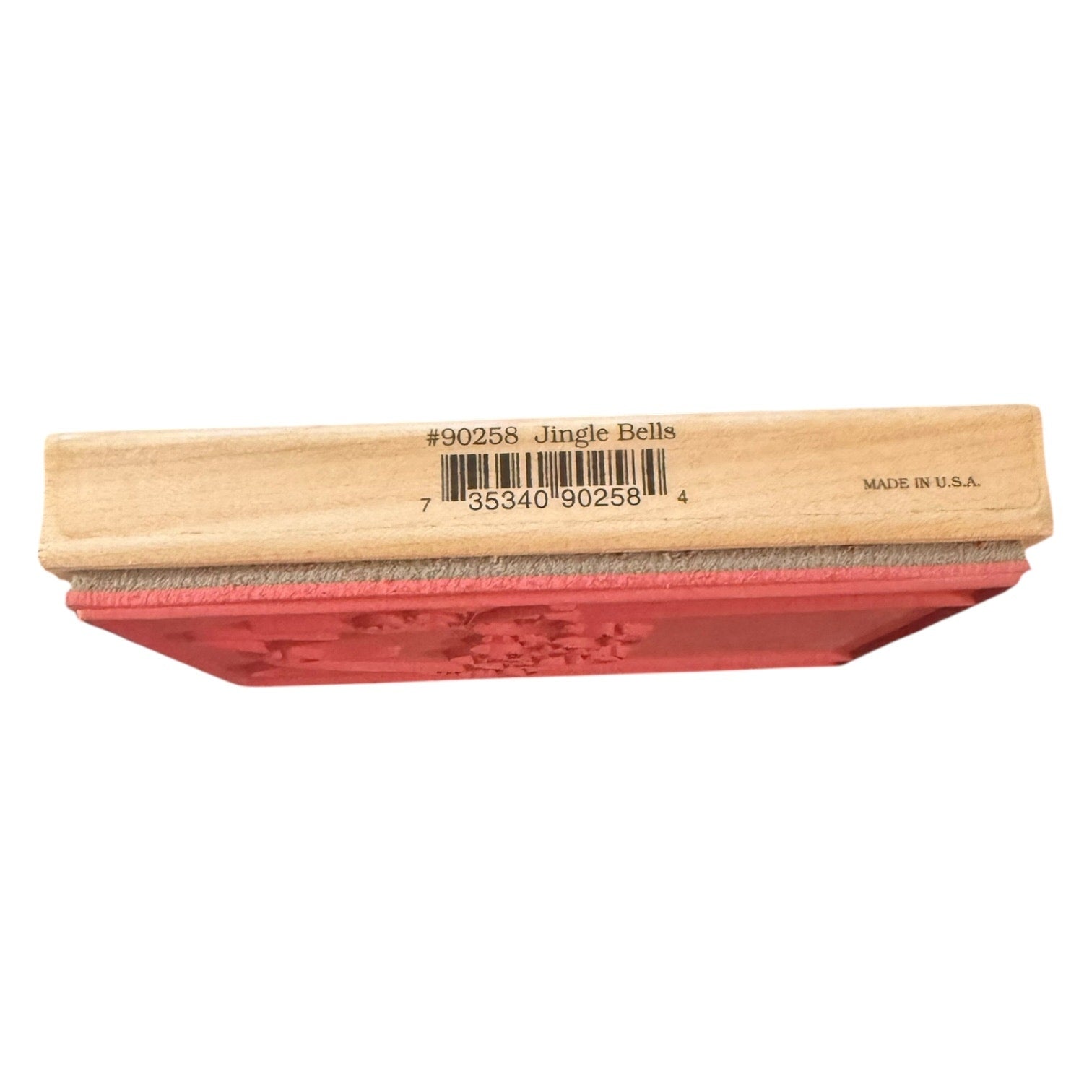Wooden stamp with red rubber pad labeled 'Jingle Bells' on a white background
