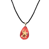 Necklace with a teardrop-shaped red pendant featuring a star design on a white background