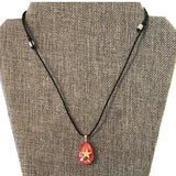 Necklace with a red teardrop pendant featuring a star on a brown textured background
