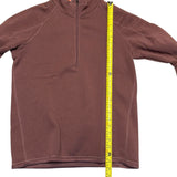 Pink fleece pullover with a measuring tape displayed on a white background
