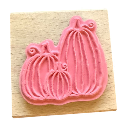 Pink pumpkin-shaped rubber stamp on a wooden block