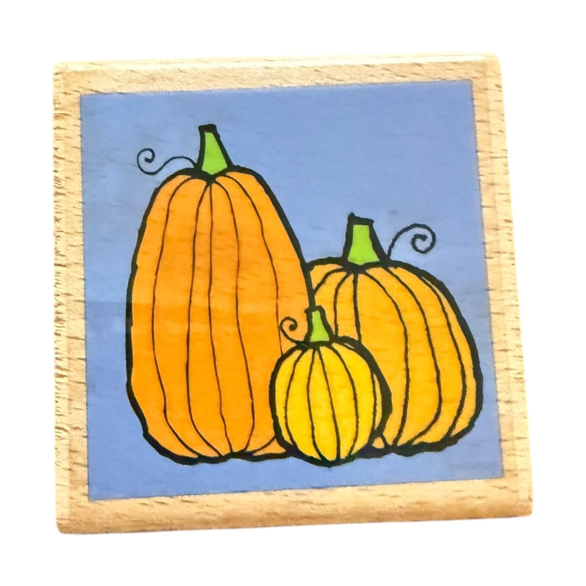 Wooden stamp with Three pumpkins on a blue background.