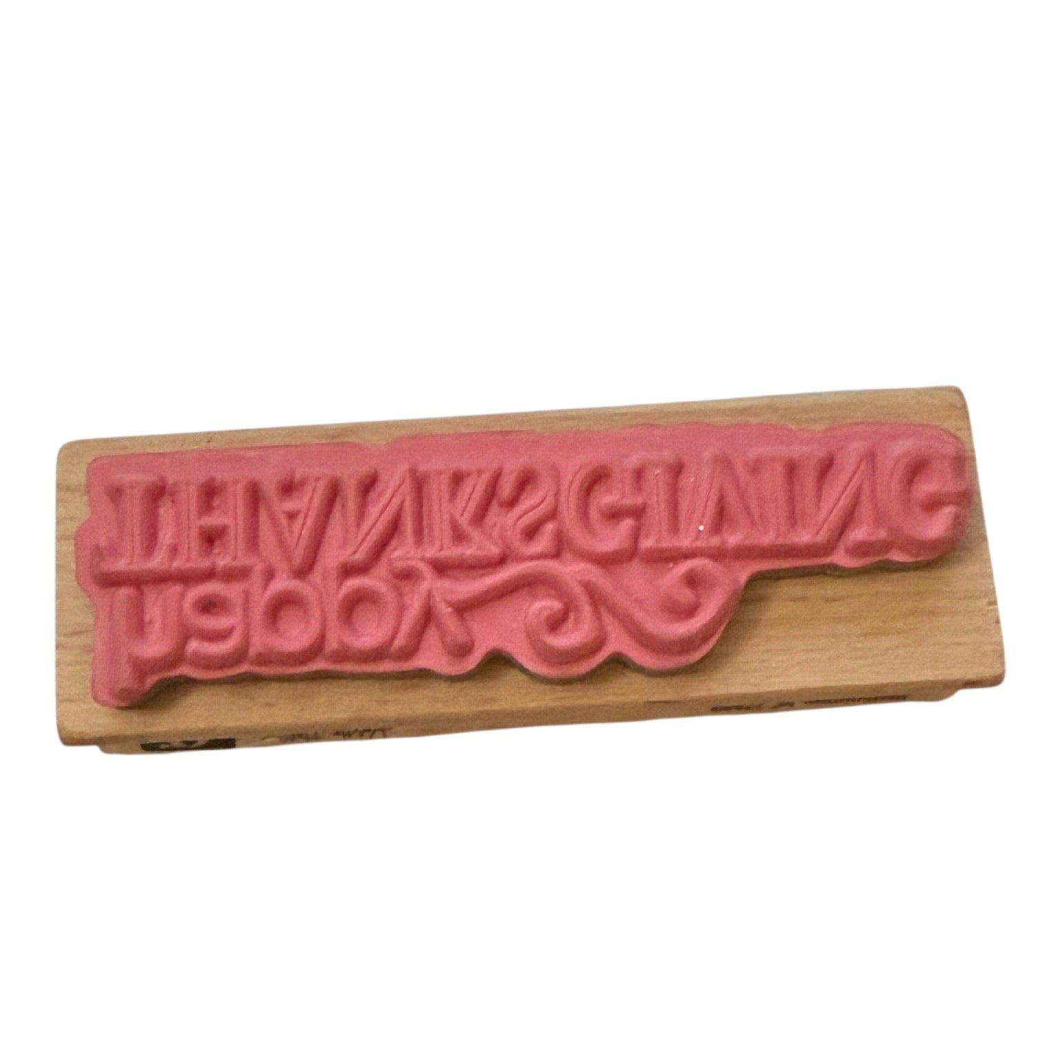 Wooden stamp with pink text on a white background