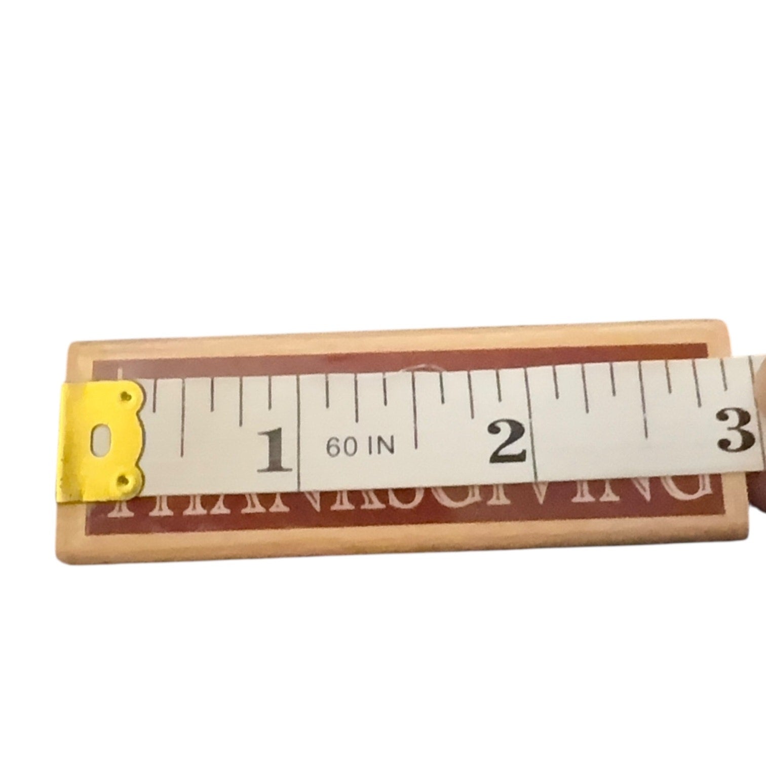 Wooden stamp with measurement scale on a white background