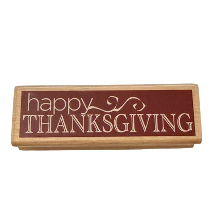 Rectangular wooden stmap with 'happy Thanksgiving' text on a white background