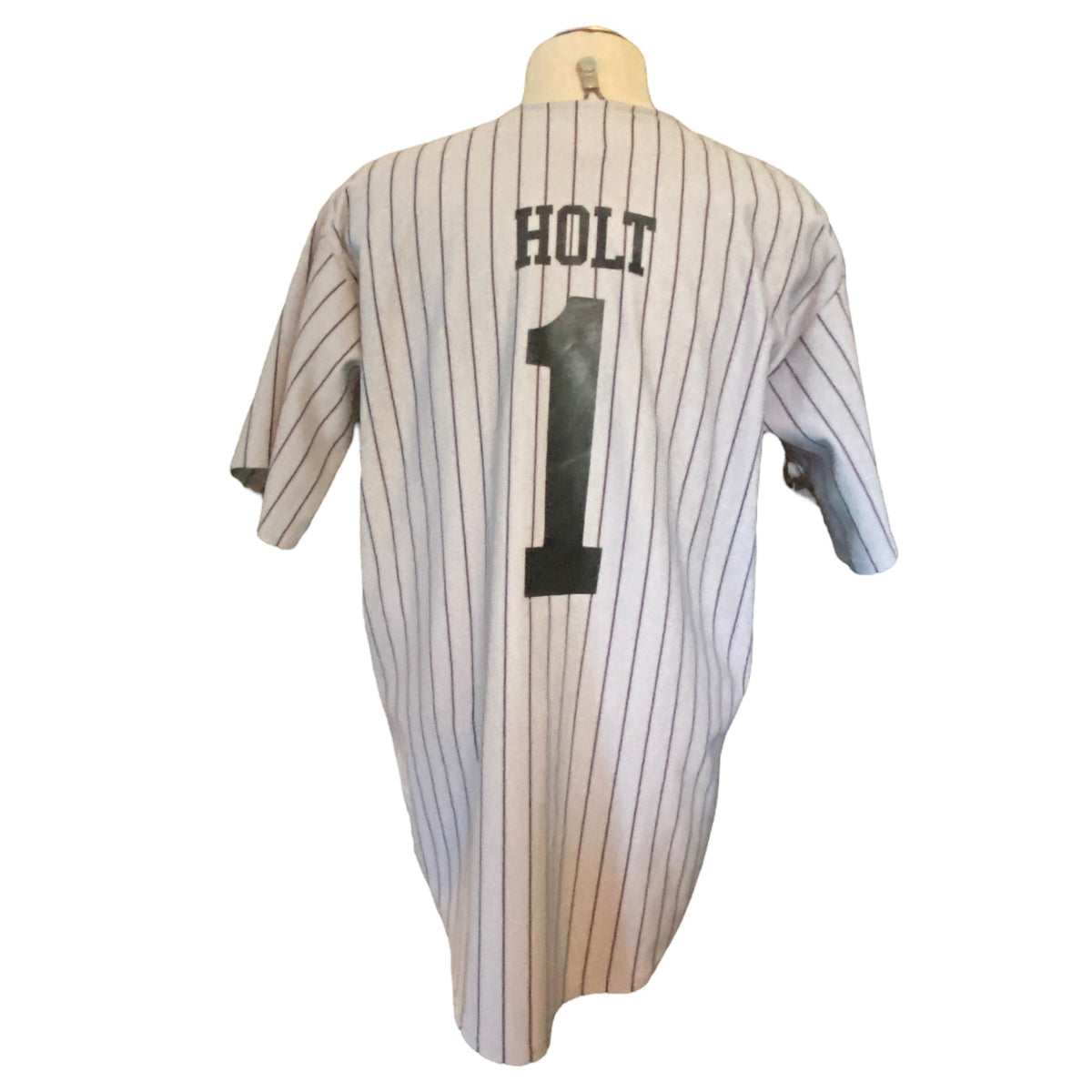 A vintage baseball jersey with thin vertical pinstripes, featuring the name 'HOLT' and the number '1' printed in black on the back, displayed on a mannequin torso against a white background.