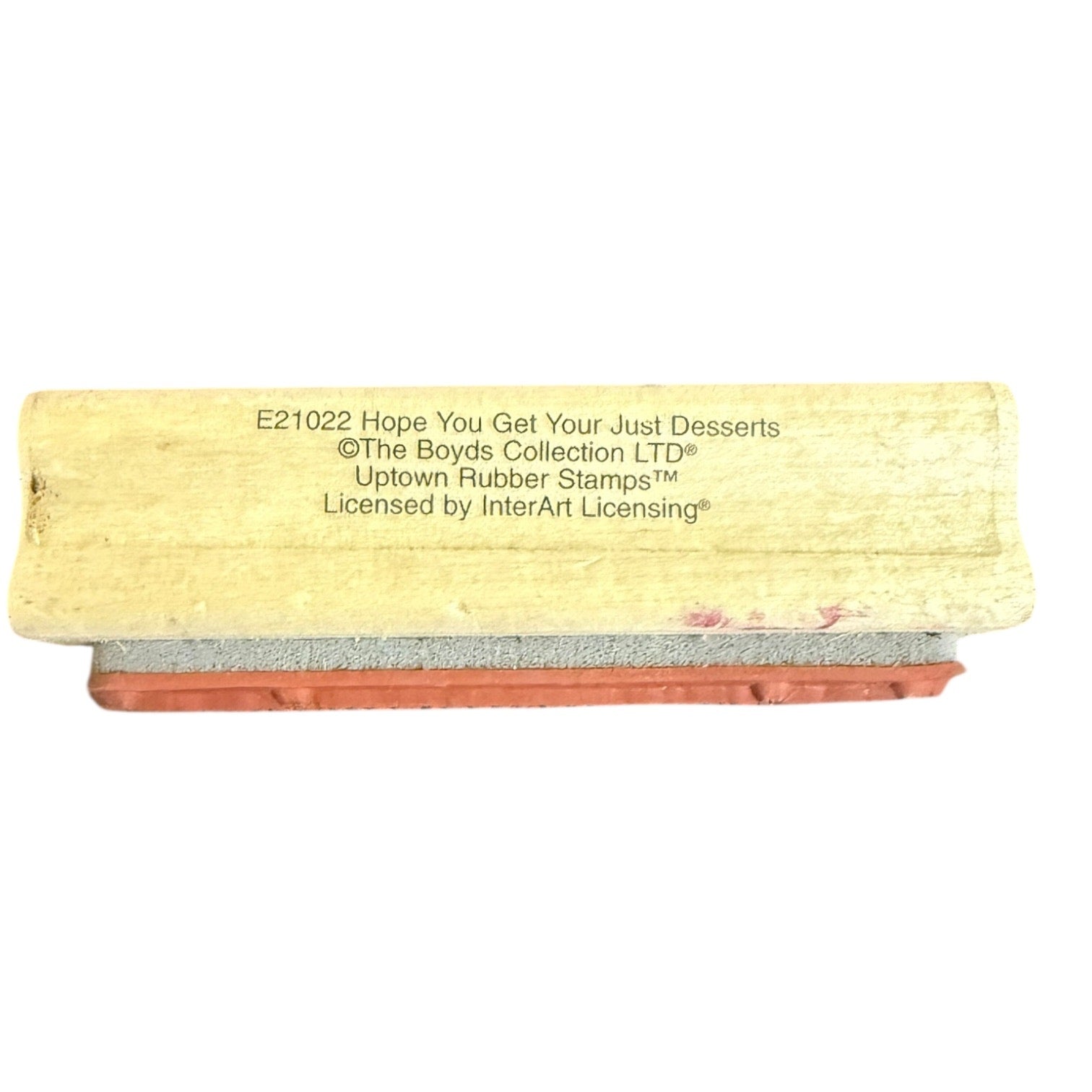 A novelty rubber stamp with a light beige wooden handle and a reddish-brown rubber stamp block, featuring the text 'E21022 Hope You Get Your Just Desserts' and '©The Boys Collection LTD'.