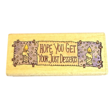 A rectangular block with a painted rustic design featuring two candles and the text 'HOPE YOU GET YOUR JUST DESSERTS' on a white background.