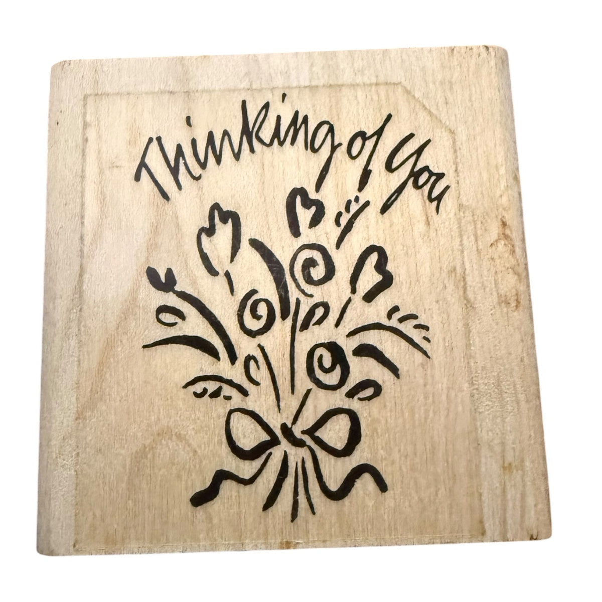 A square wooden stamp with a design that reads 'Thinking of You' above a bouquet of flowers and a bow, shown on a plain white background.