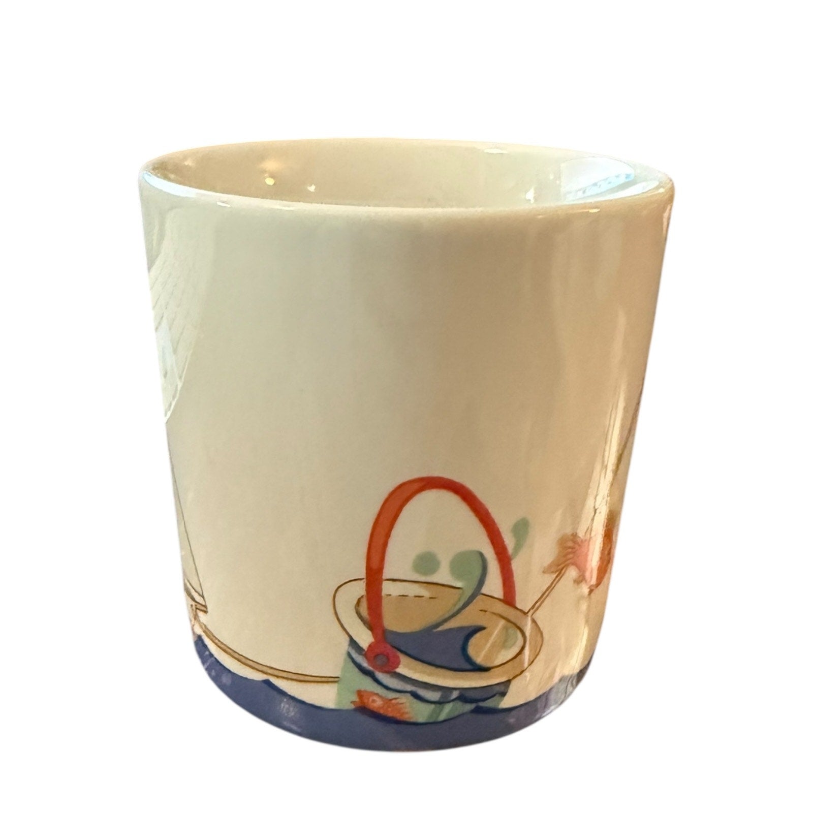Mug with the sea, bucket and fish on a white background