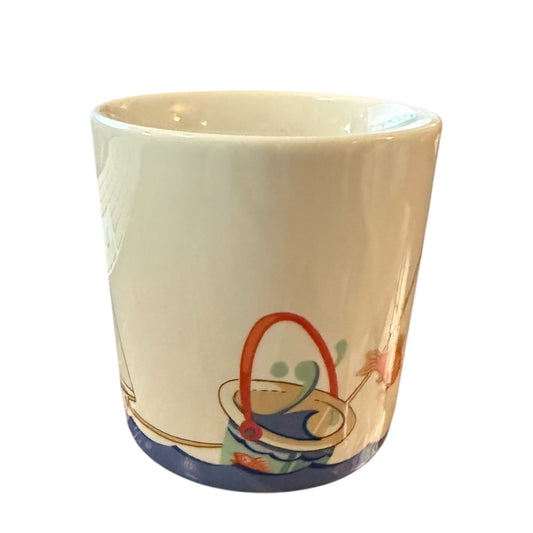 Mug with the sea, bucket and fish on a white background