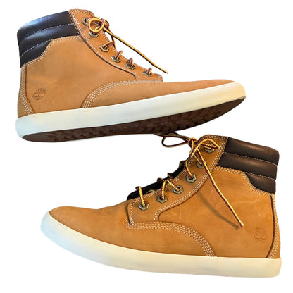 Pair of tan high-top boots with white soles on a white background