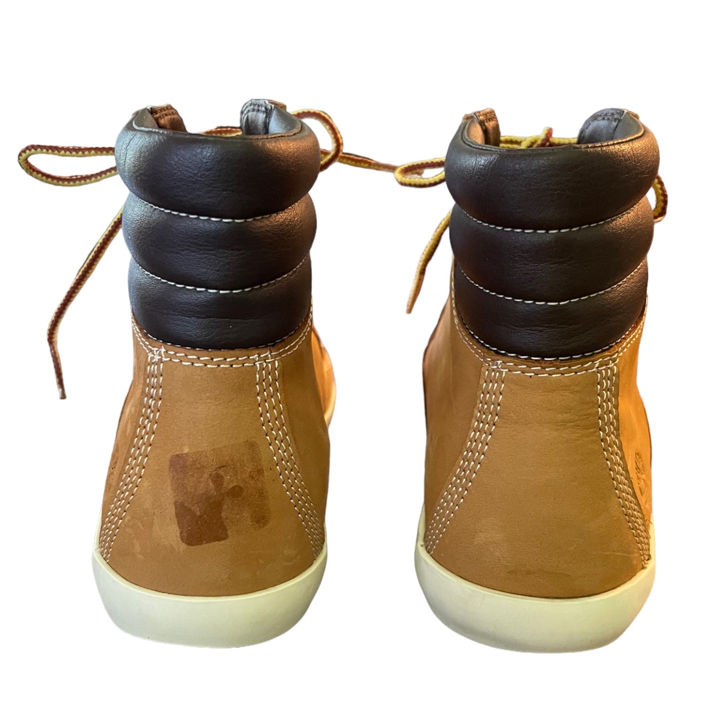 Pair of brown leather boots with white soles on a white background