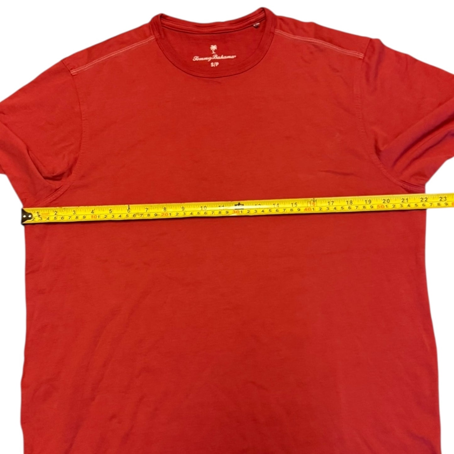 Red t-shirt with a measuring tape across it on a white background
