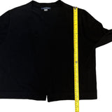 Black cardigan with a measuring tape running diagonally across it on a white background