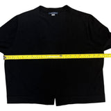 Black cardigan with a yellow measuring tape across it on a white background