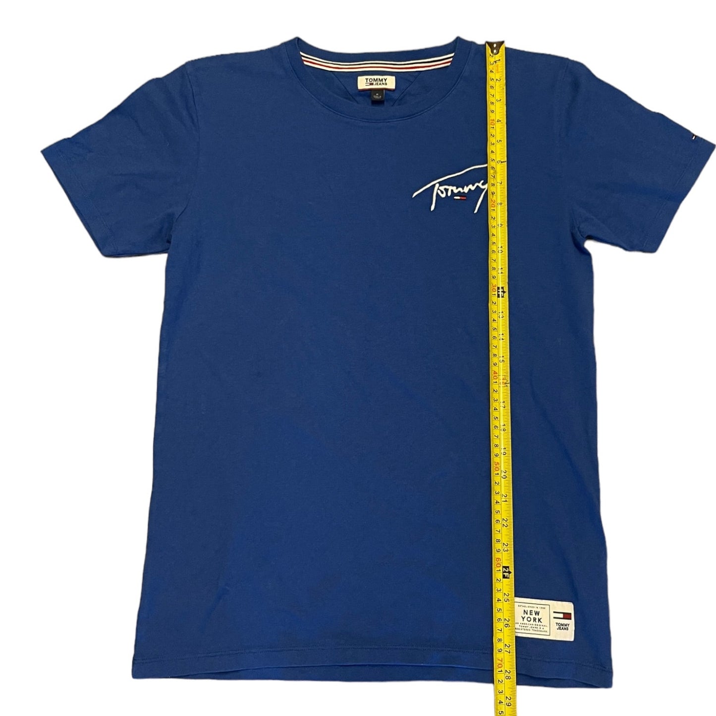 Blue t-shirt with a measuring tape on a white background