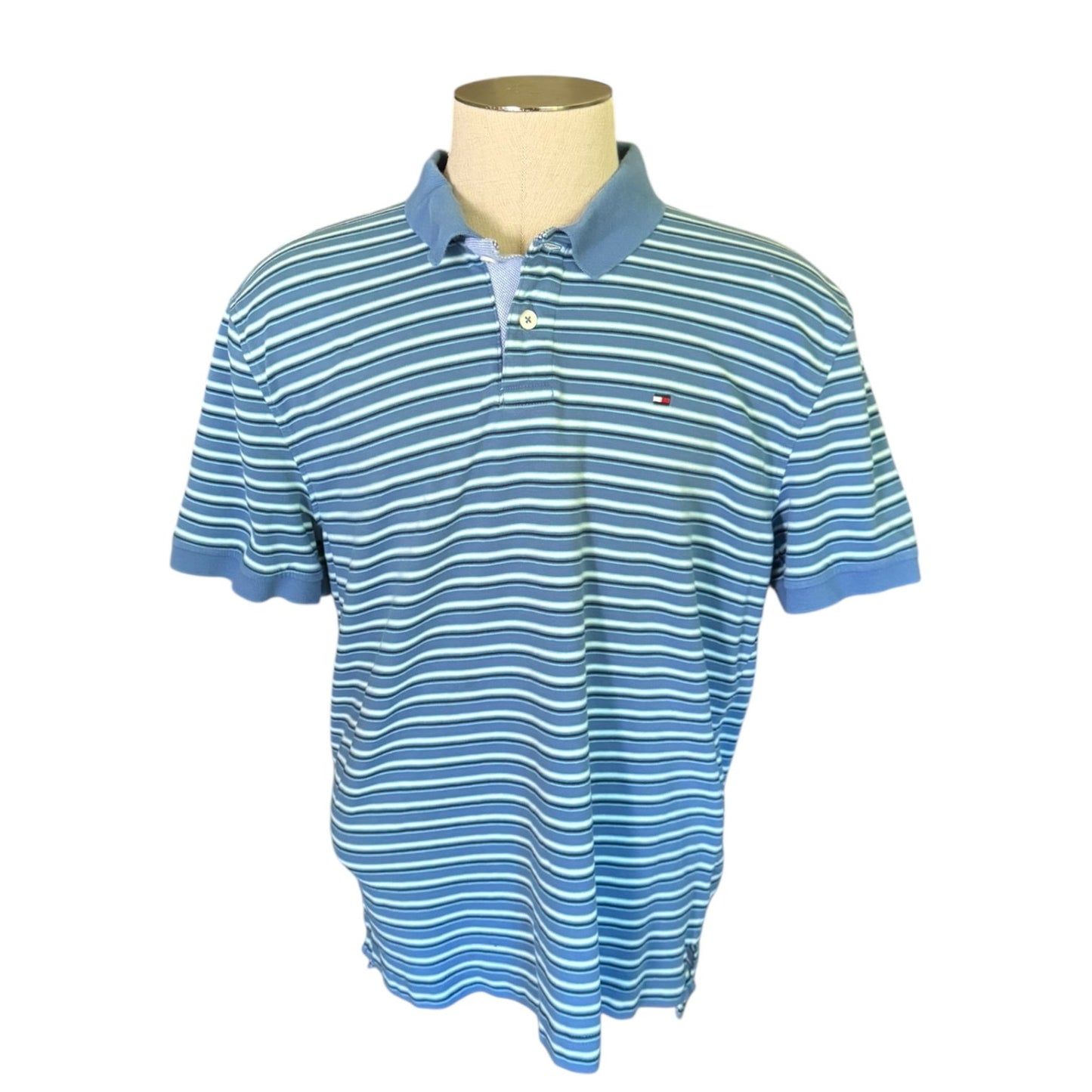 Front of Blue and white striped polo shirt on a mannequin with a white background