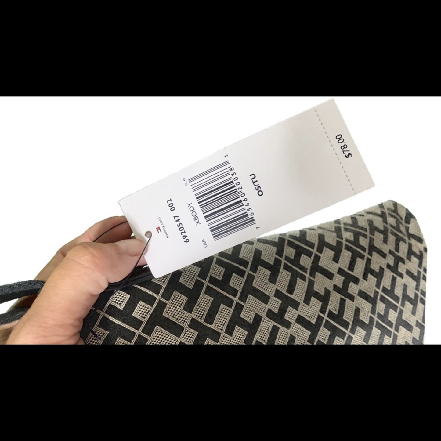 Hand holding a product tag with a barcode and on a white background