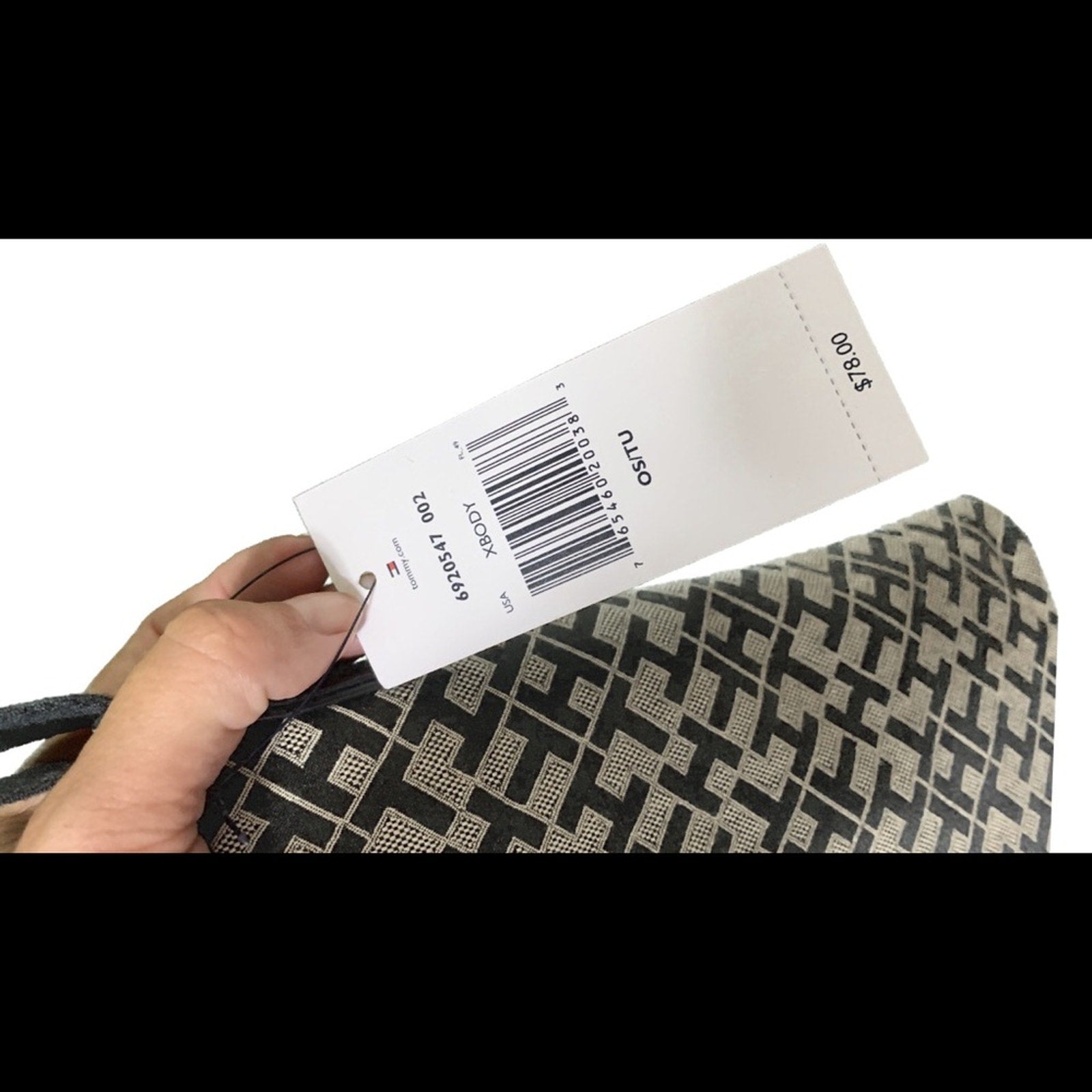 Hand holding a product tag with a barcode and on a white background