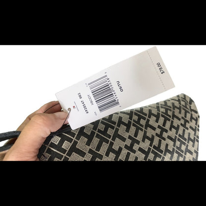 Hand holding a product tag with a barcode and on a white background