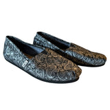 Pair of paisley patterned loafers on a white background