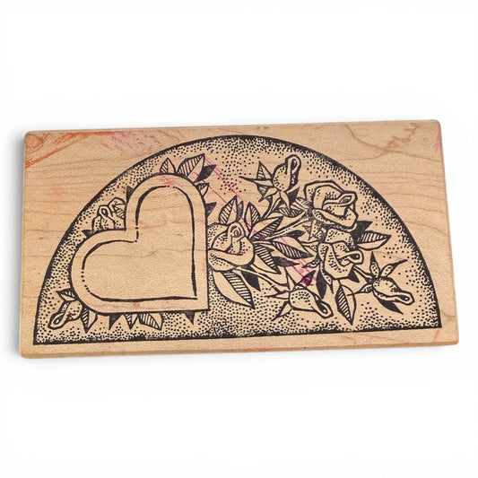 Wooden stamp with heart and floral design on a white background