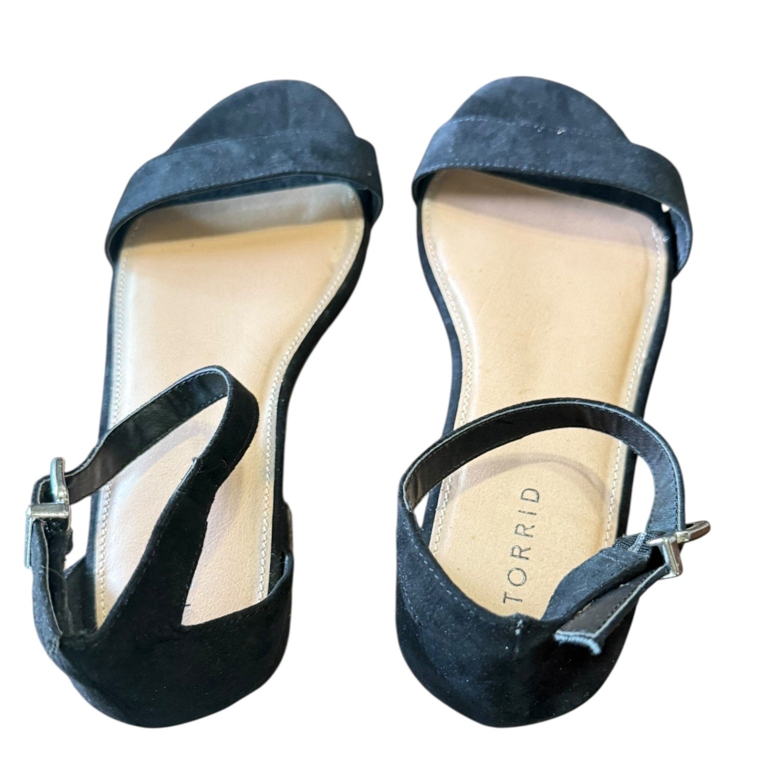 Top view of Pair of black black shoes with 'Torrid' branding on a white background