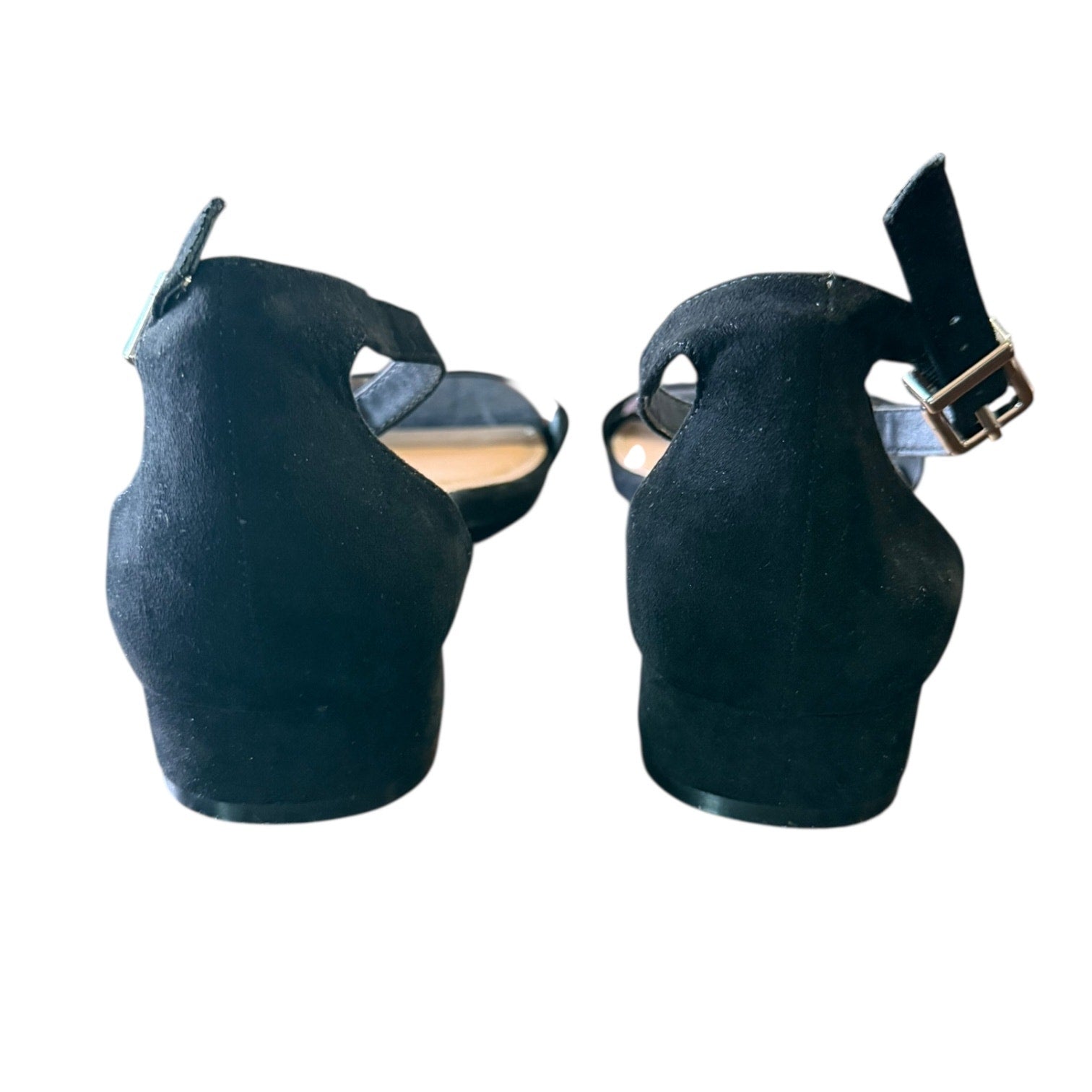 Back of black shoes with a strap on a white background