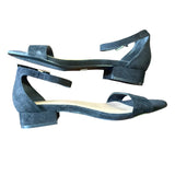 Pair of black suede shoes with a block heel on a white background
