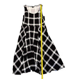 Black and white checkered dress with a measuring tape on a white background