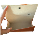 Hand holding a orange case with a visible brand label on a white background