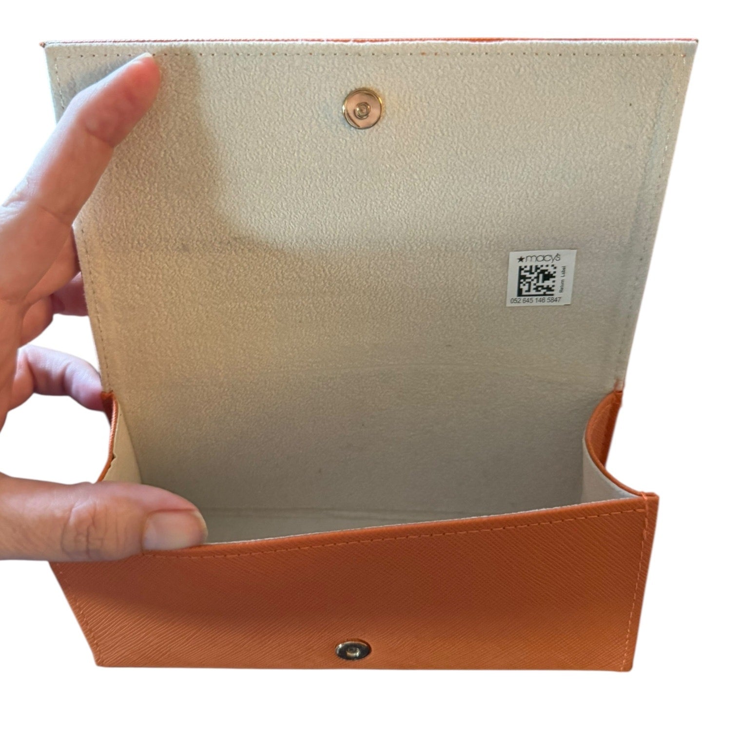 Beige interior with orange trim held by a hand on a white background