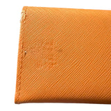 Close-up of an orange textured fabric with a brand logo showing issues