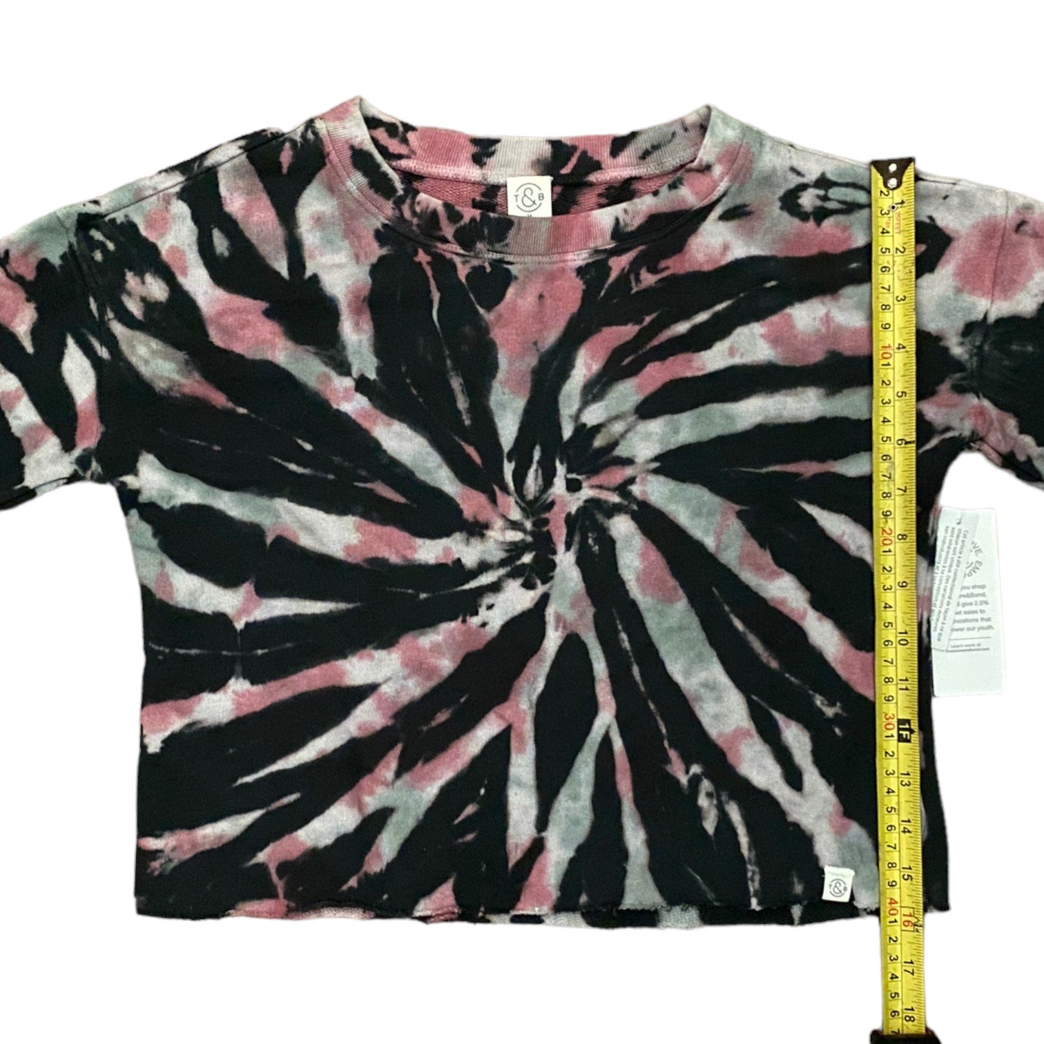 Tie-dye t-shirt with black, pink, and white pattern, measured with a tape measure.