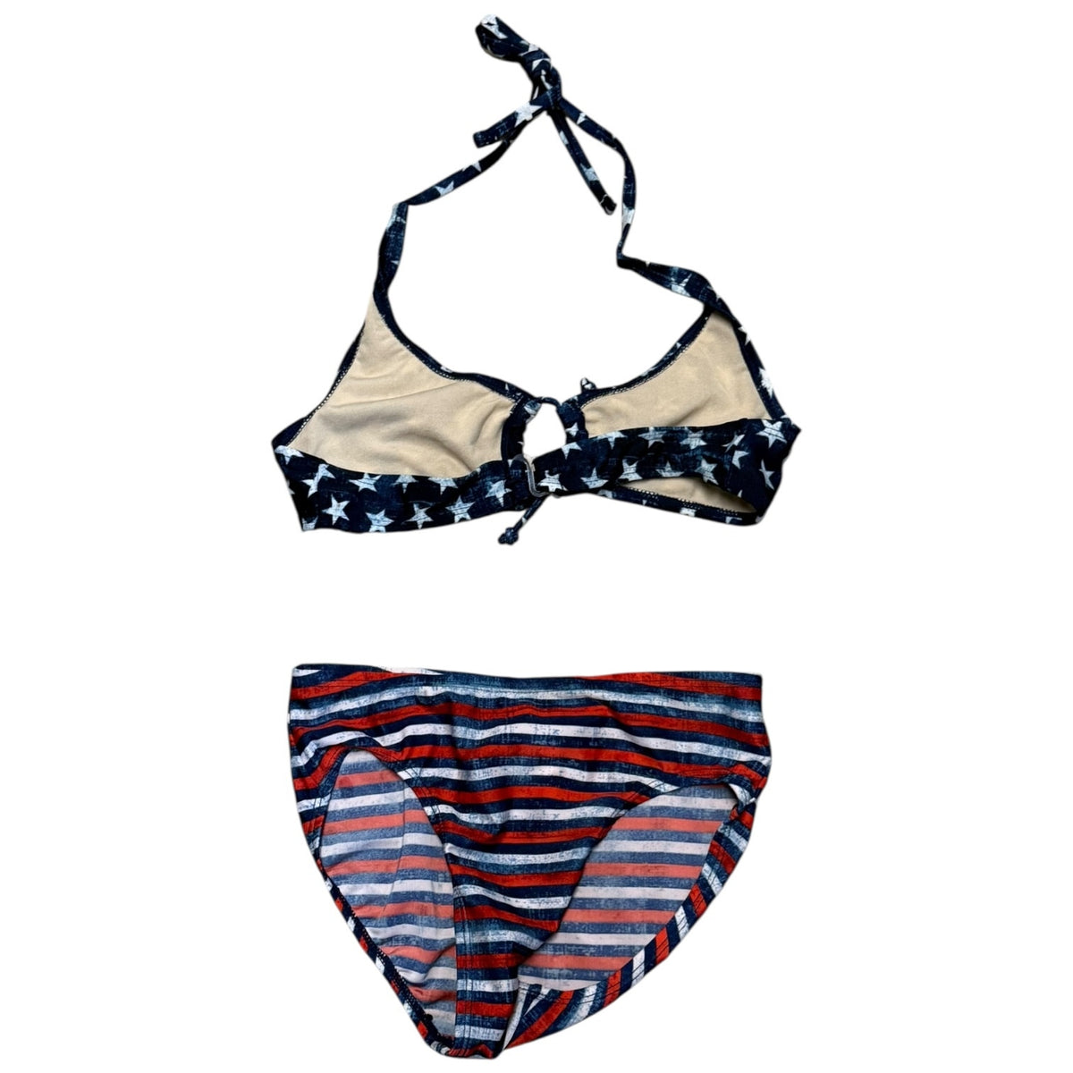 A two-piece bikini set laid flat on a white background. The top is a halter-style triangle bikini with navy blue straps and trim featuring white stars, and beige cups.