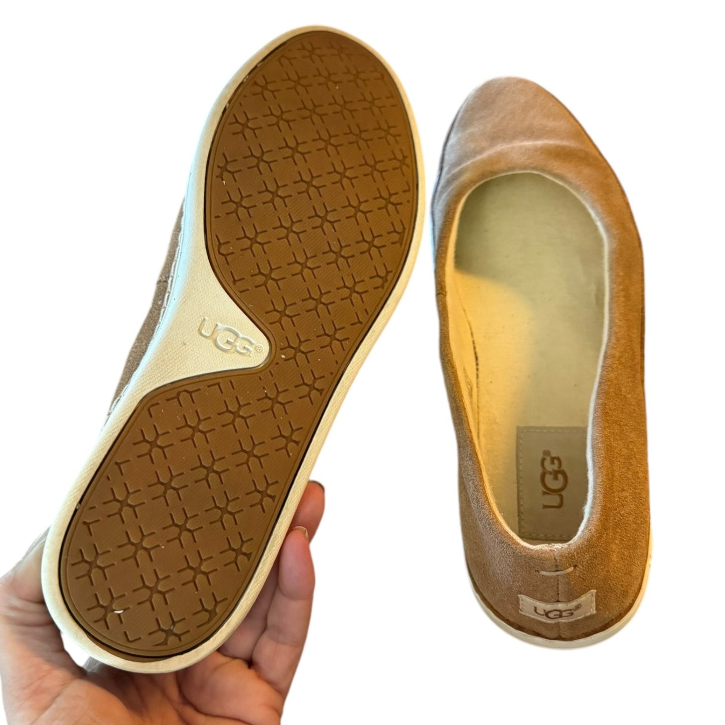 Brown UGG shoe with sole showing brand logo on a white background
