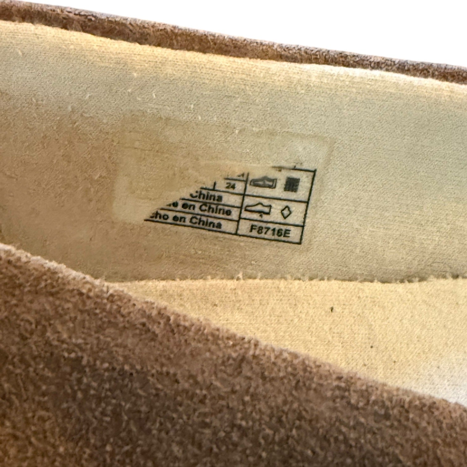 Close-up of a label on the inside of a shoe with text and symbols.