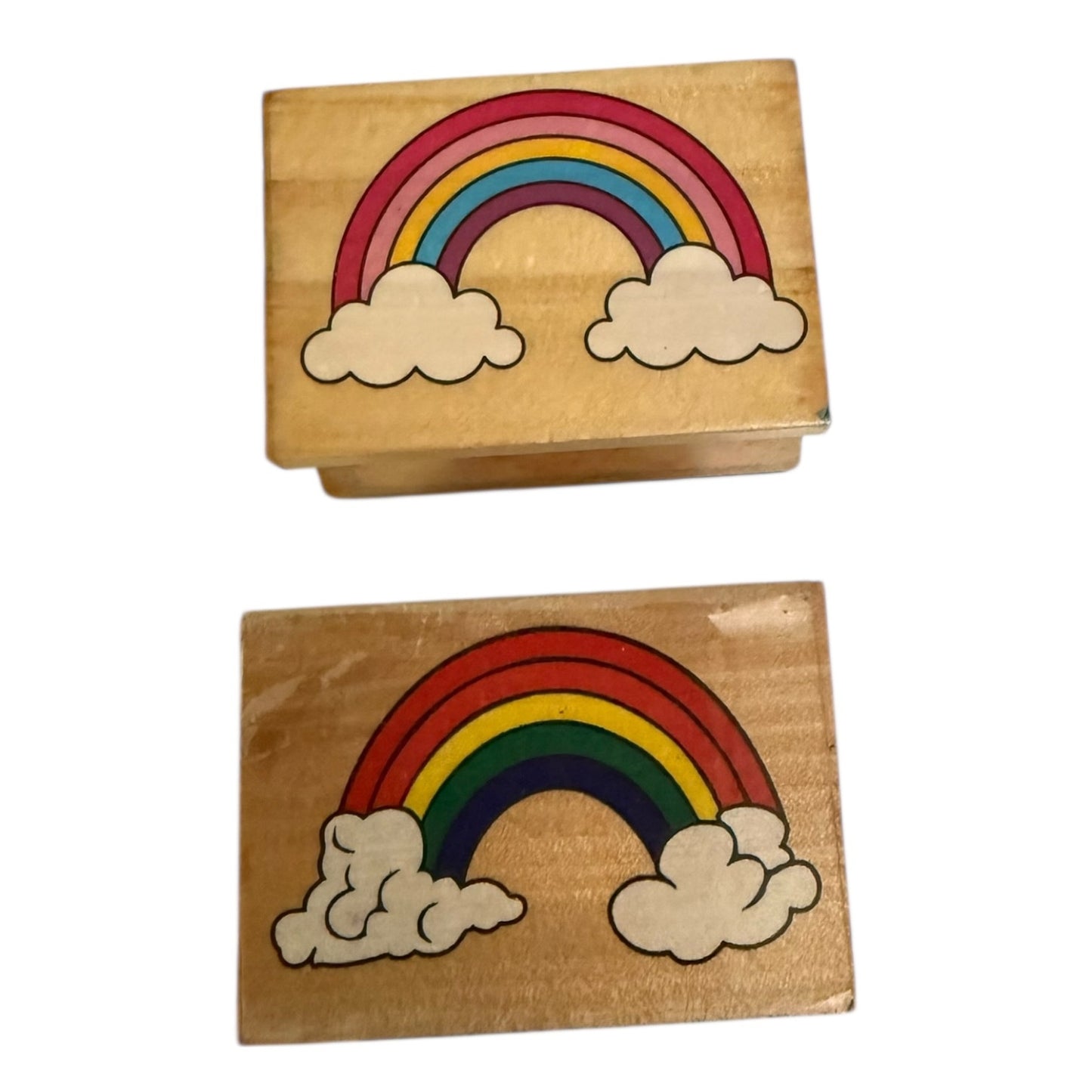 Two wooden stamps with rainbow and cloud designs on a white background